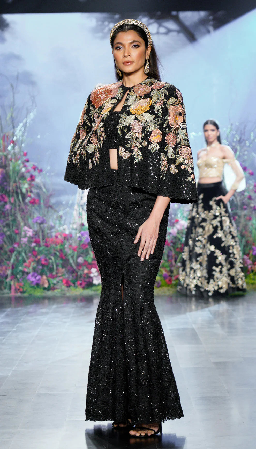 Charcoal black, crepe silk cape, florals, rose gold zardozi, glass beads, sequins, matching crop top, fluted skirt, tonal embroidery, black cape, evening celebrations, cocktail gatherings, wedding