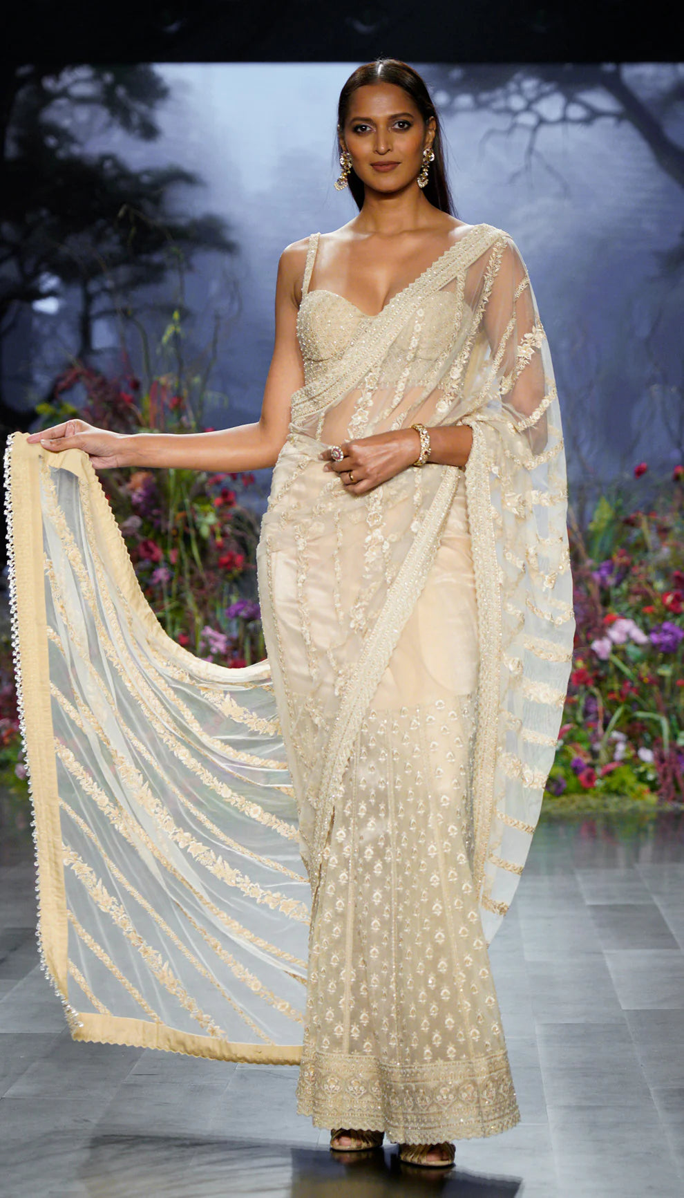 Woman in ivory saree on a fashion show runway for designers Shyamal and Bhumika