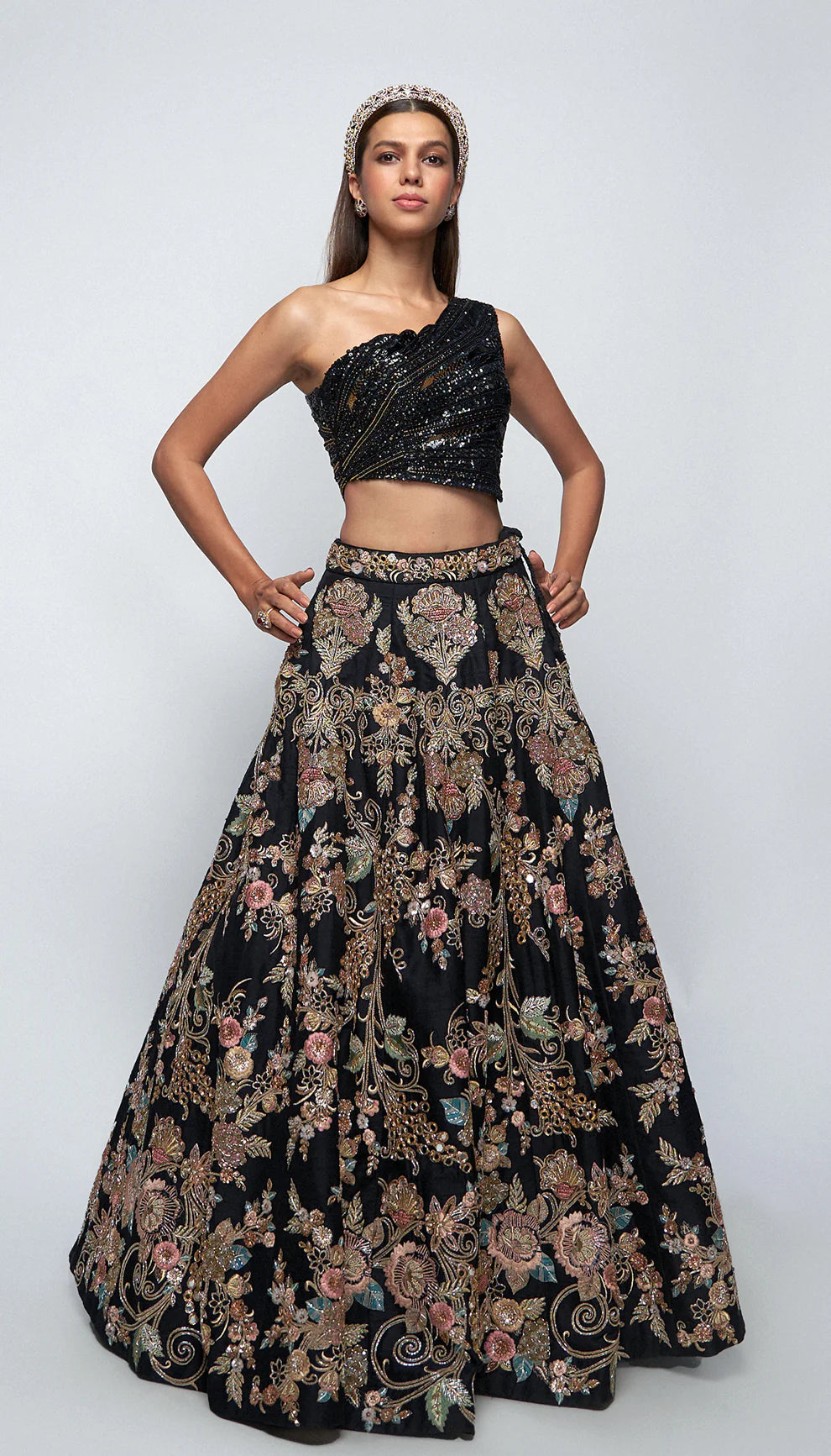 Woman wearing black and gold lehenga against a white background for designers Shyamal and Bhumika.
