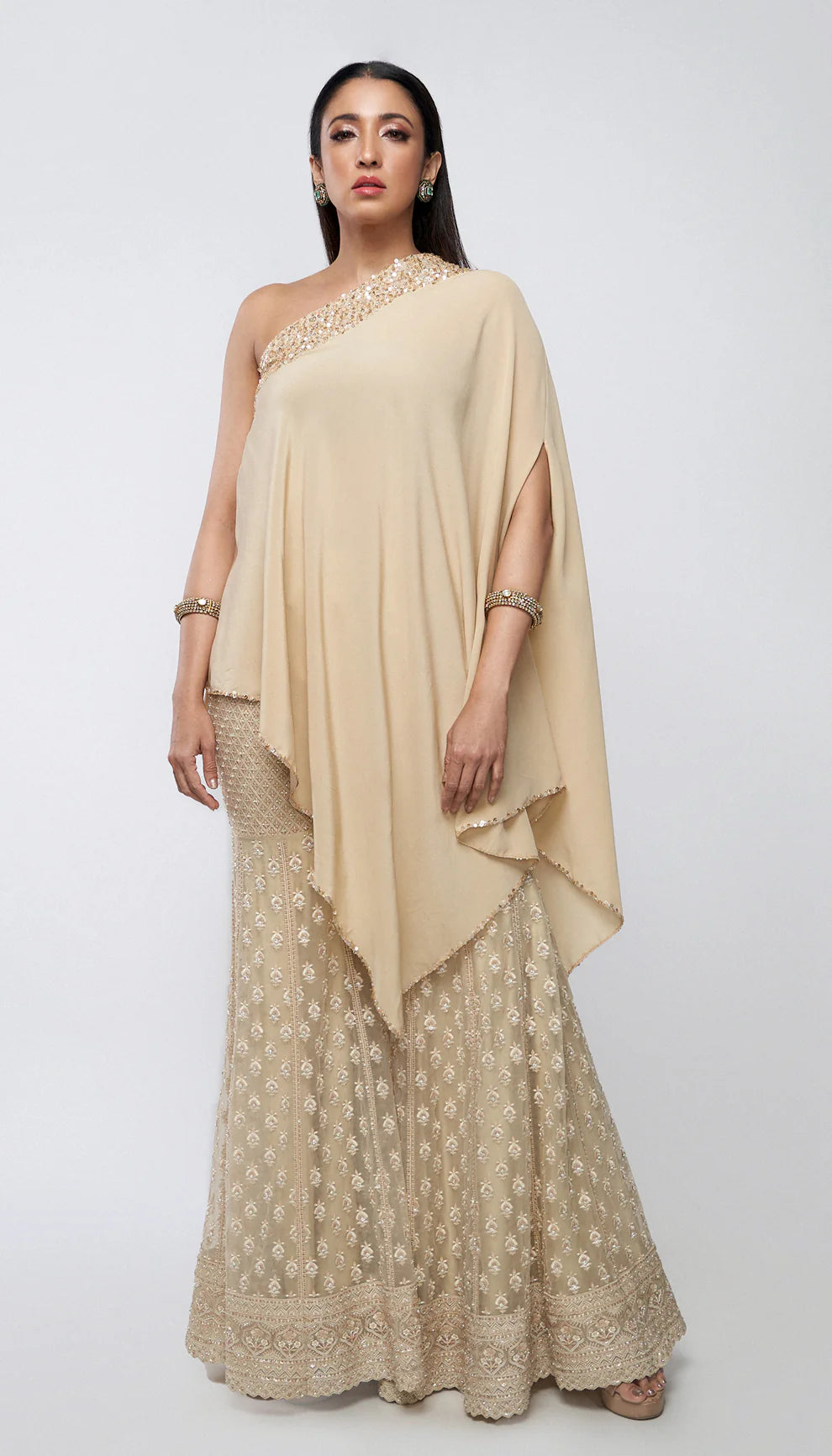 Almond beige tulle net sharara, resham embroidery, glass beads, sequins, crystals, crepe silk one- shoulder kurti, weddings, festive celebrations, evening occasions