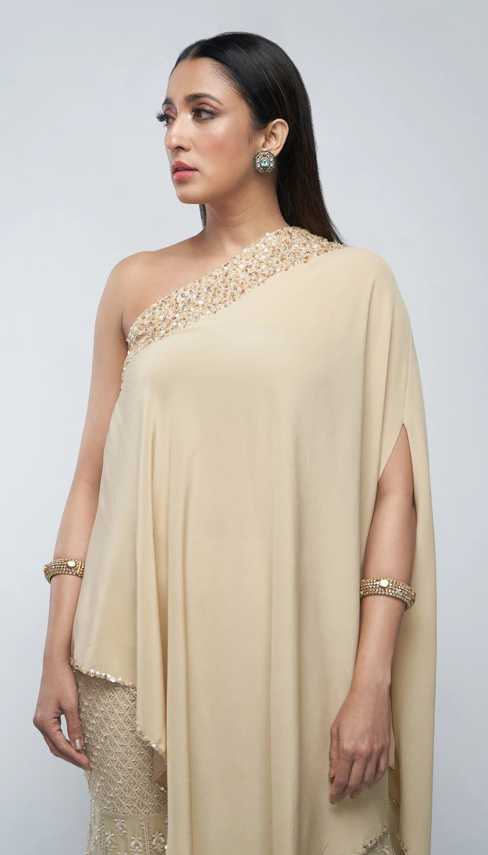 Almond beige tulle net sharara, resham embroidery, glass beads, sequins, crystals, crepe silk one- shoulder kurti, weddings, festive celebrations, evening occasions