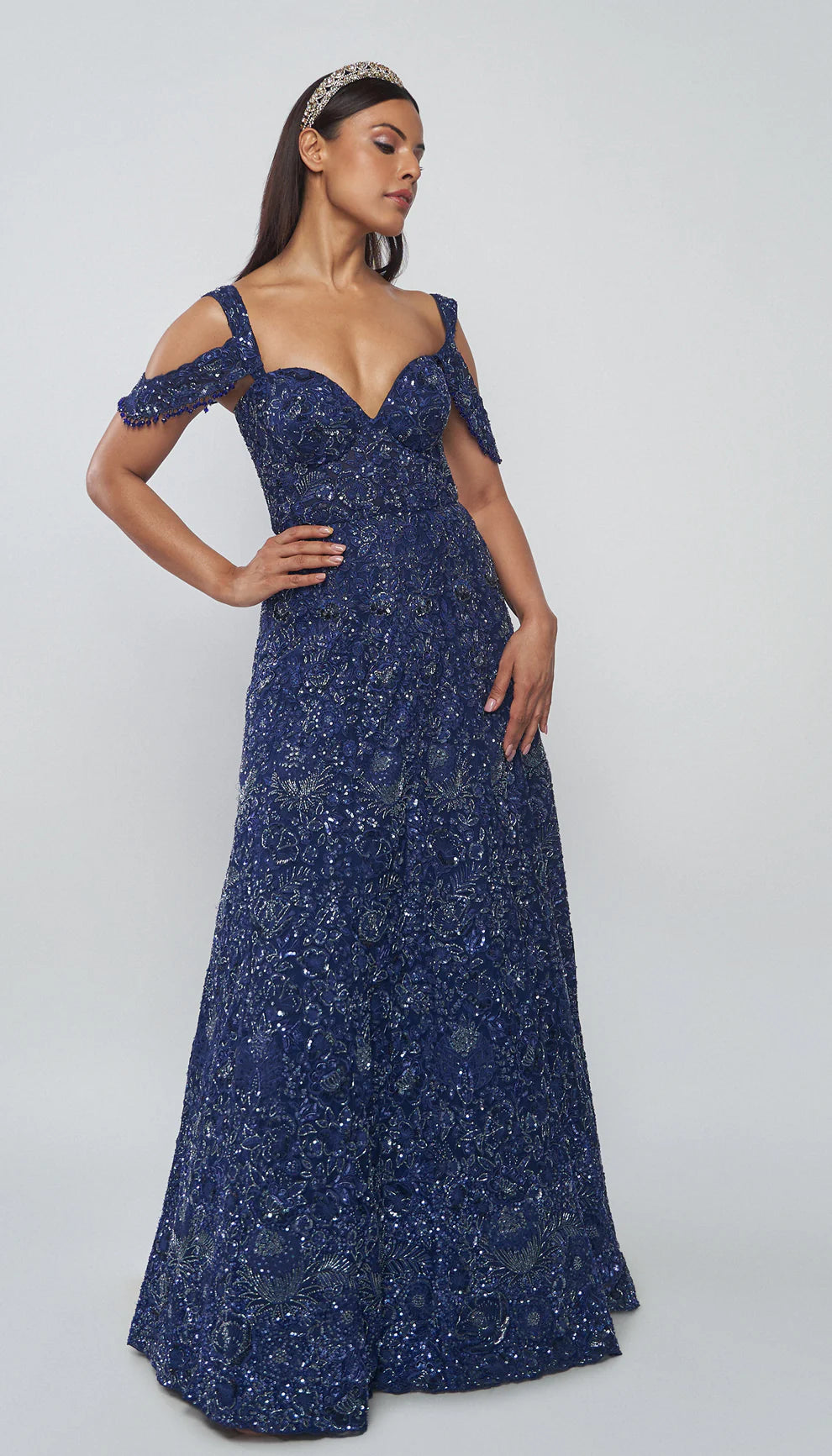 Model wearing a blue evening gown against a white background for designers Shyamal and Bhumika