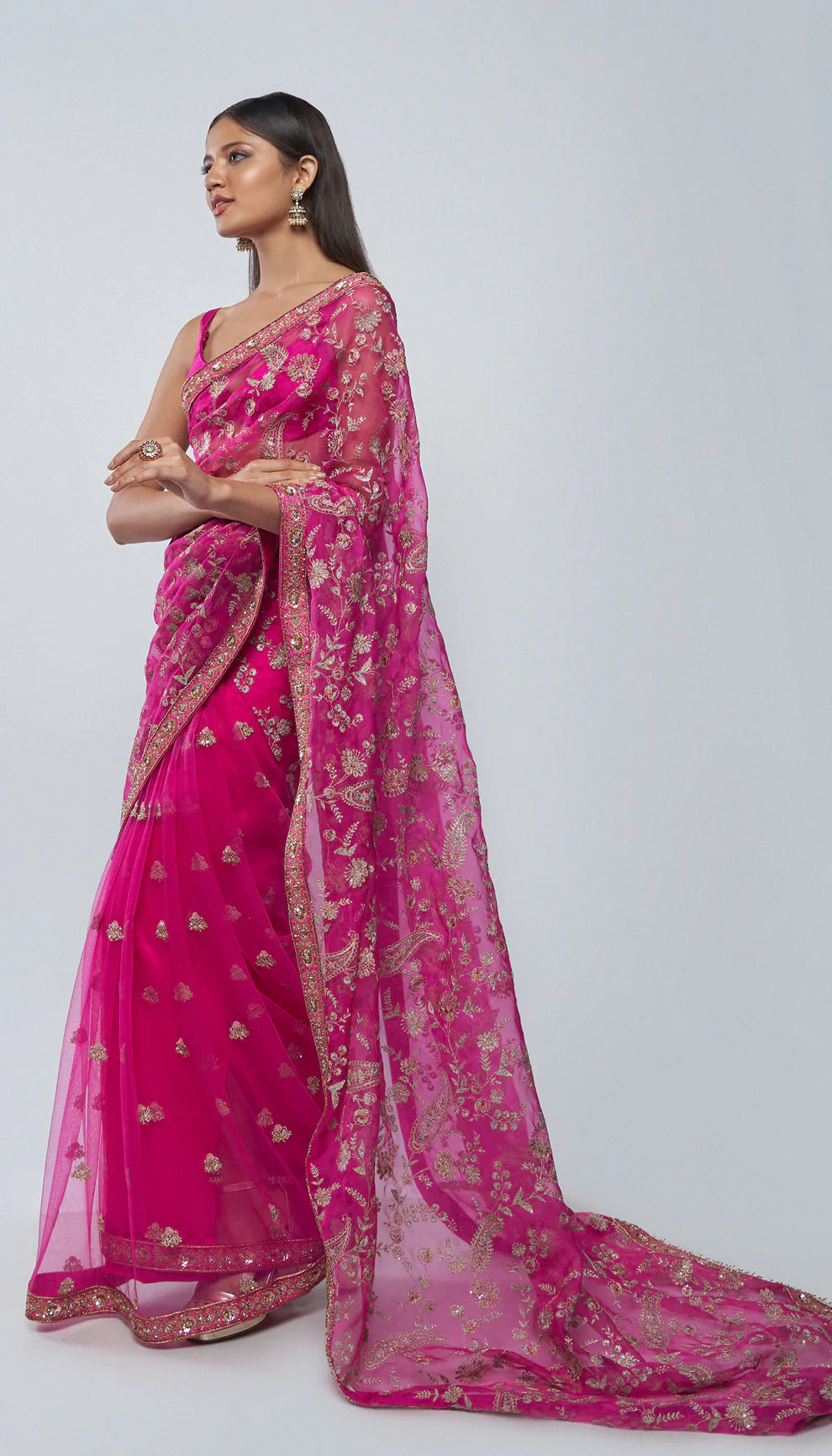 Woman in a pink saree with a white background for designers Shyamal and Bhumika.