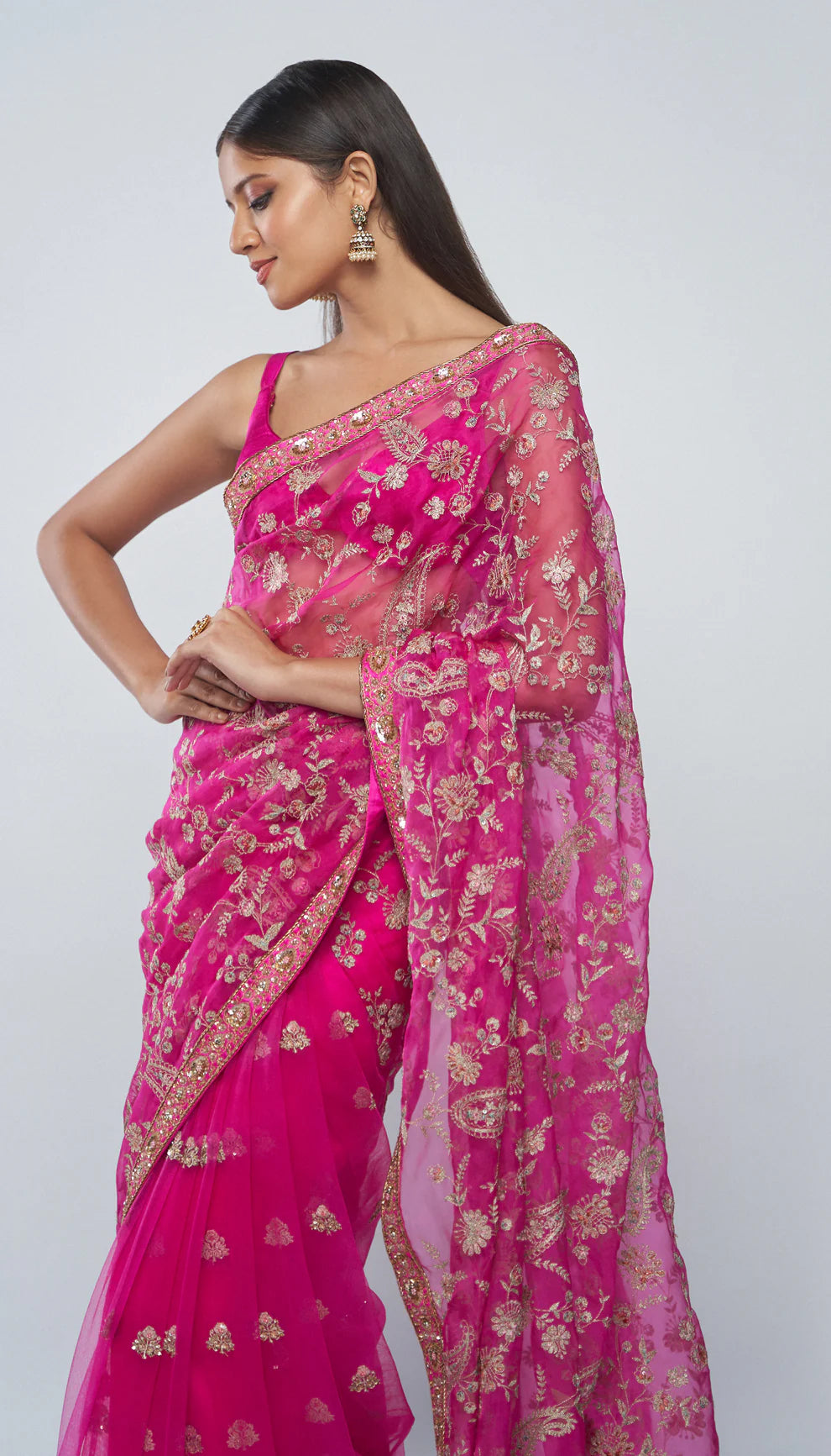 Woman in a pink saree with a white background for designers Shyamal and Bhumika.