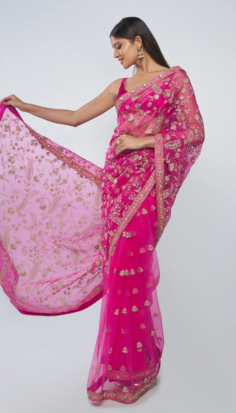 Woman in a pink saree with a white background for designers Shyamal and Bhumika.