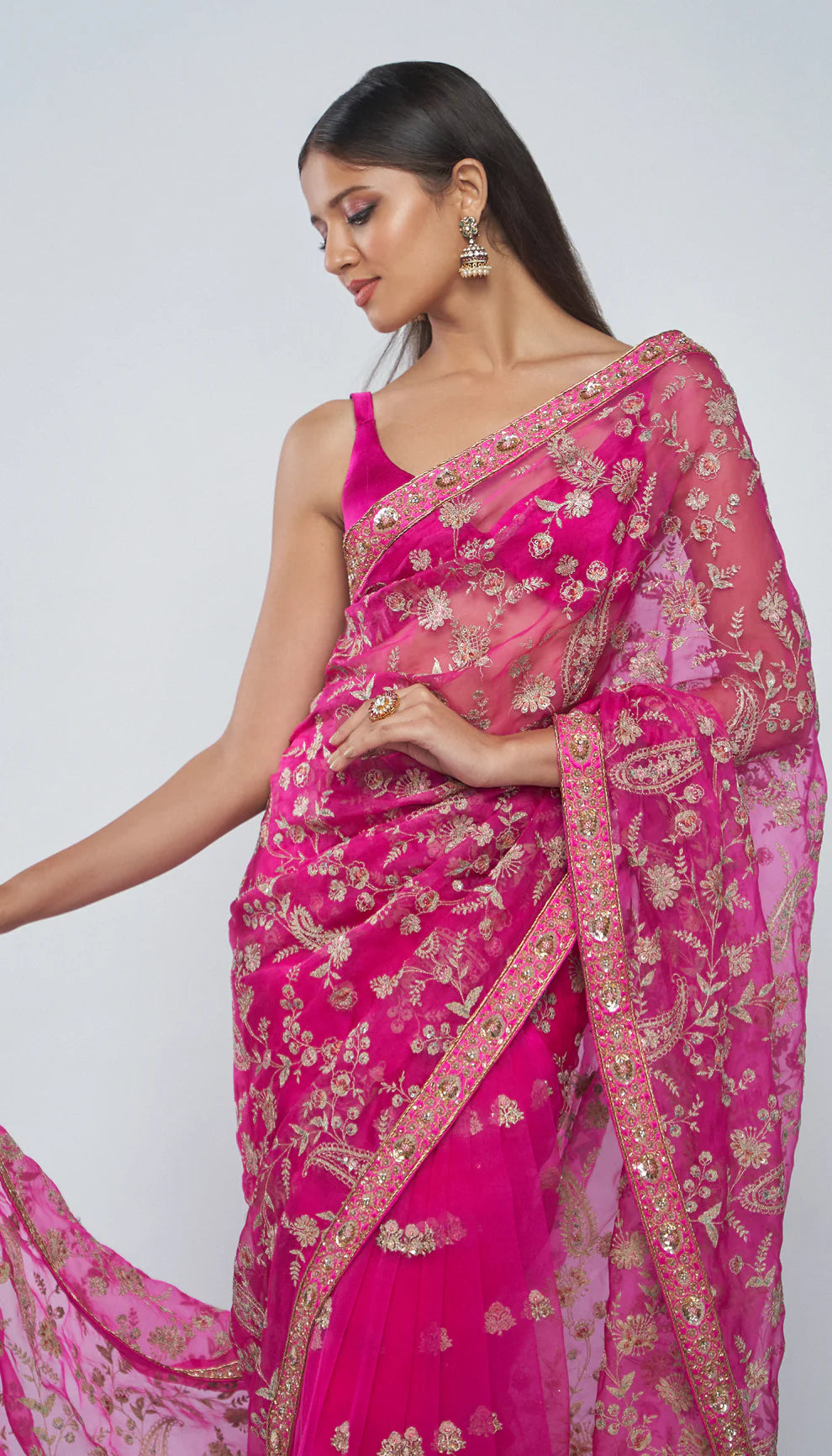 Woman in a pink saree with a white background for designers Shyamal and Bhumika.