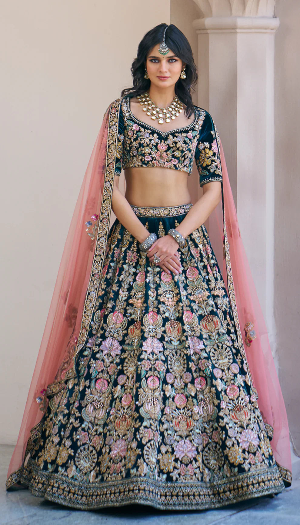 Woman wearing a traditional green embroidered lehenga with a pink dupatta by designers Shyamal and Bhumika.