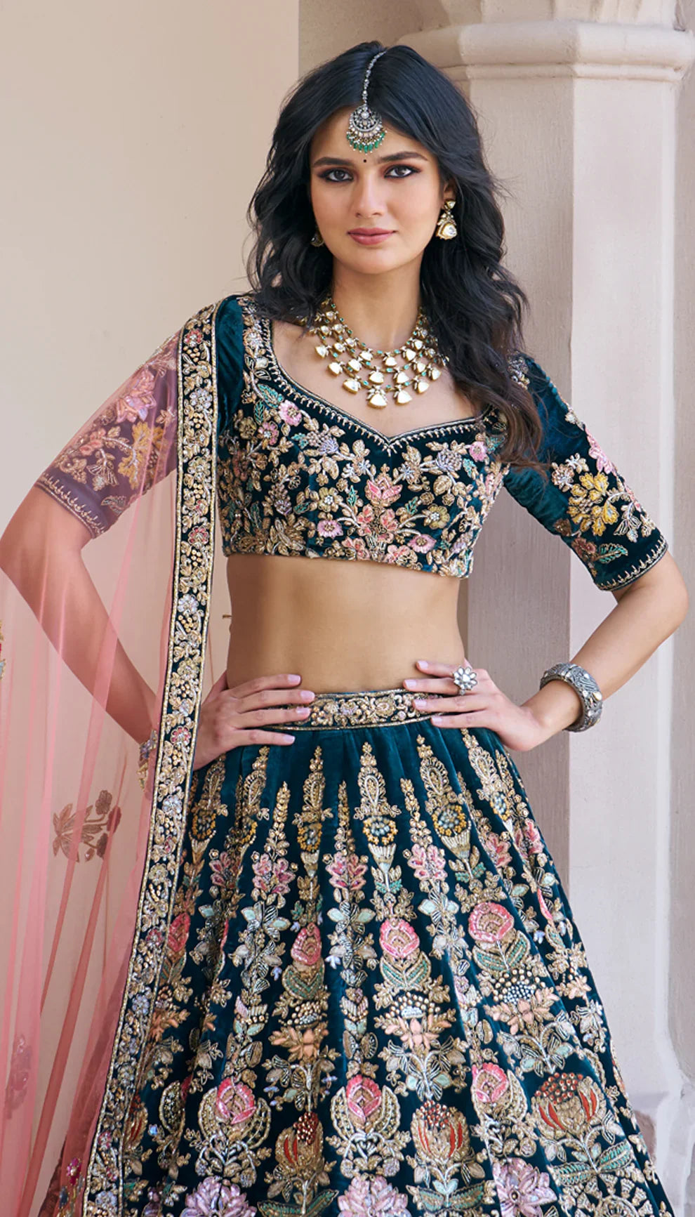 Woman wearing a traditional green embroidered lehenga with a pink dupatta by designers Shyamal and Bhumika.