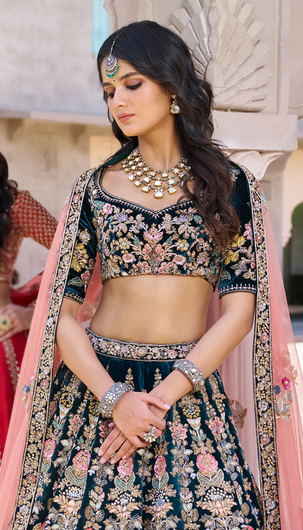 Woman wearing a traditional green embroidered lehenga with a pink dupatta by designers Shyamal and Bhumika.