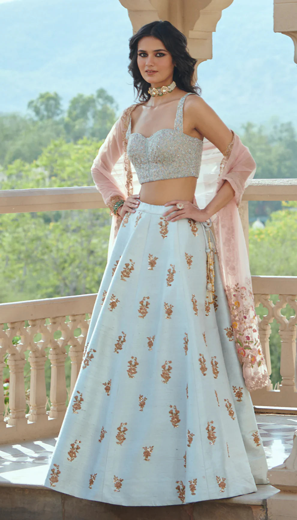 Woman in a light blue embroidered lehenga with a pink dupatta by designers Shyamal and Bhumika.