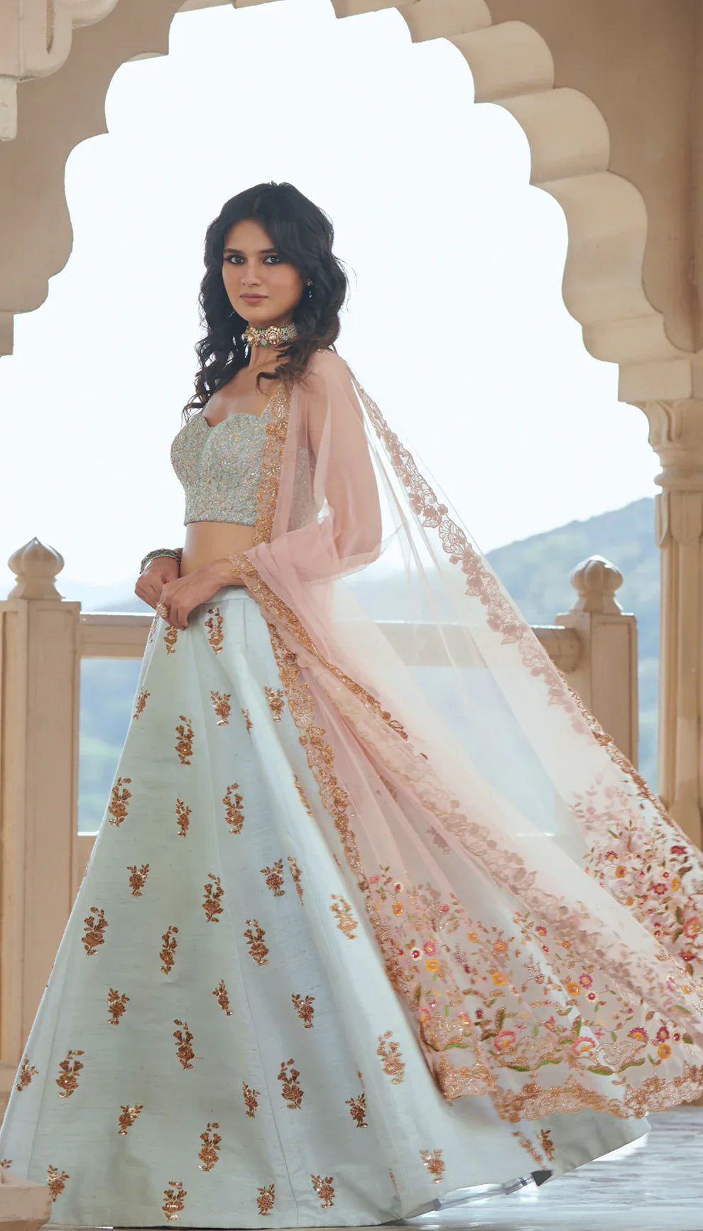 Woman in a light blue embroidered lehenga with a pink dupatta by designers Shyamal and Bhumika.