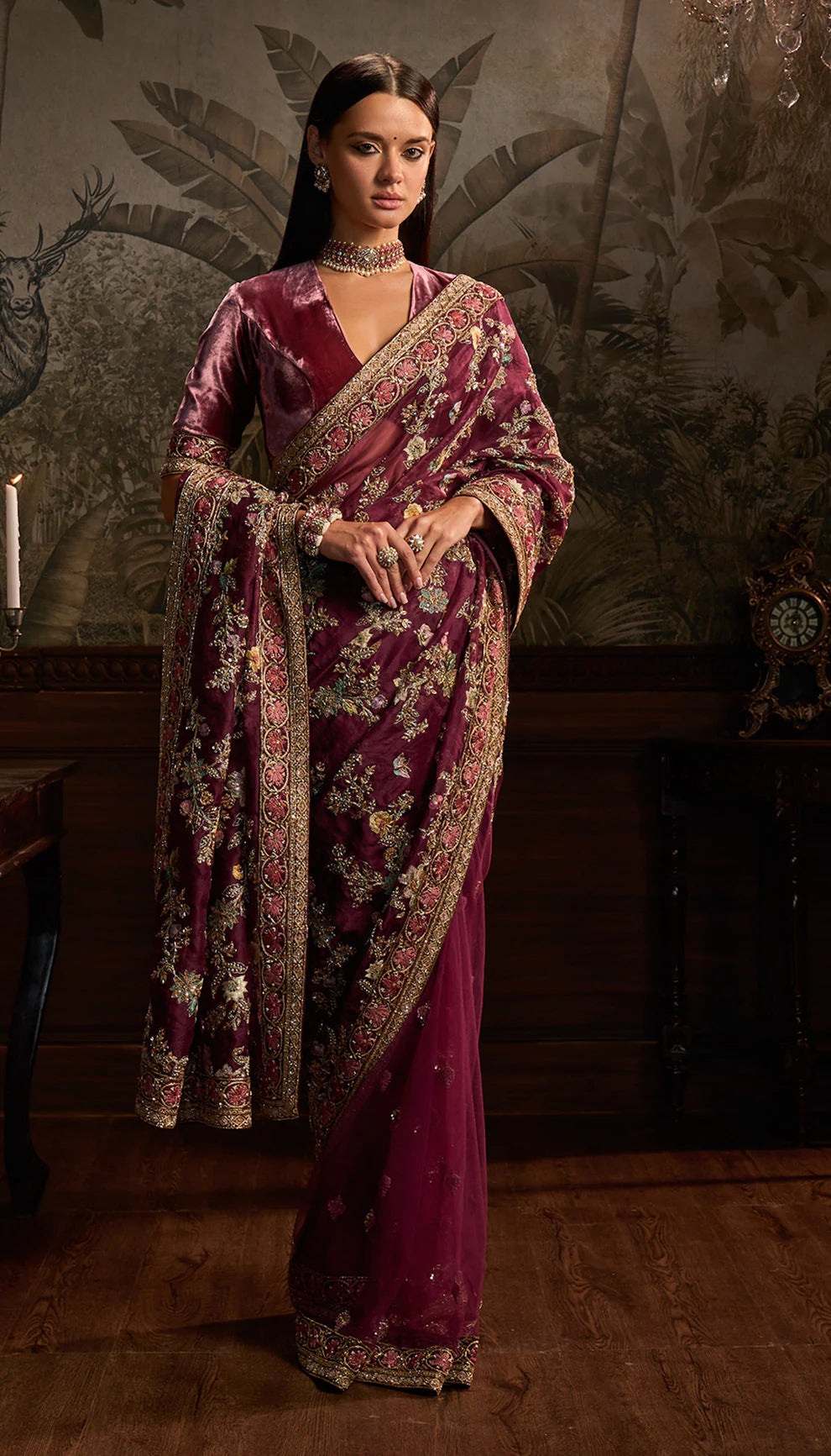 Woman wearing a purple saree with floral patterns by designers Shyamal and Bhumika in a decorative setting