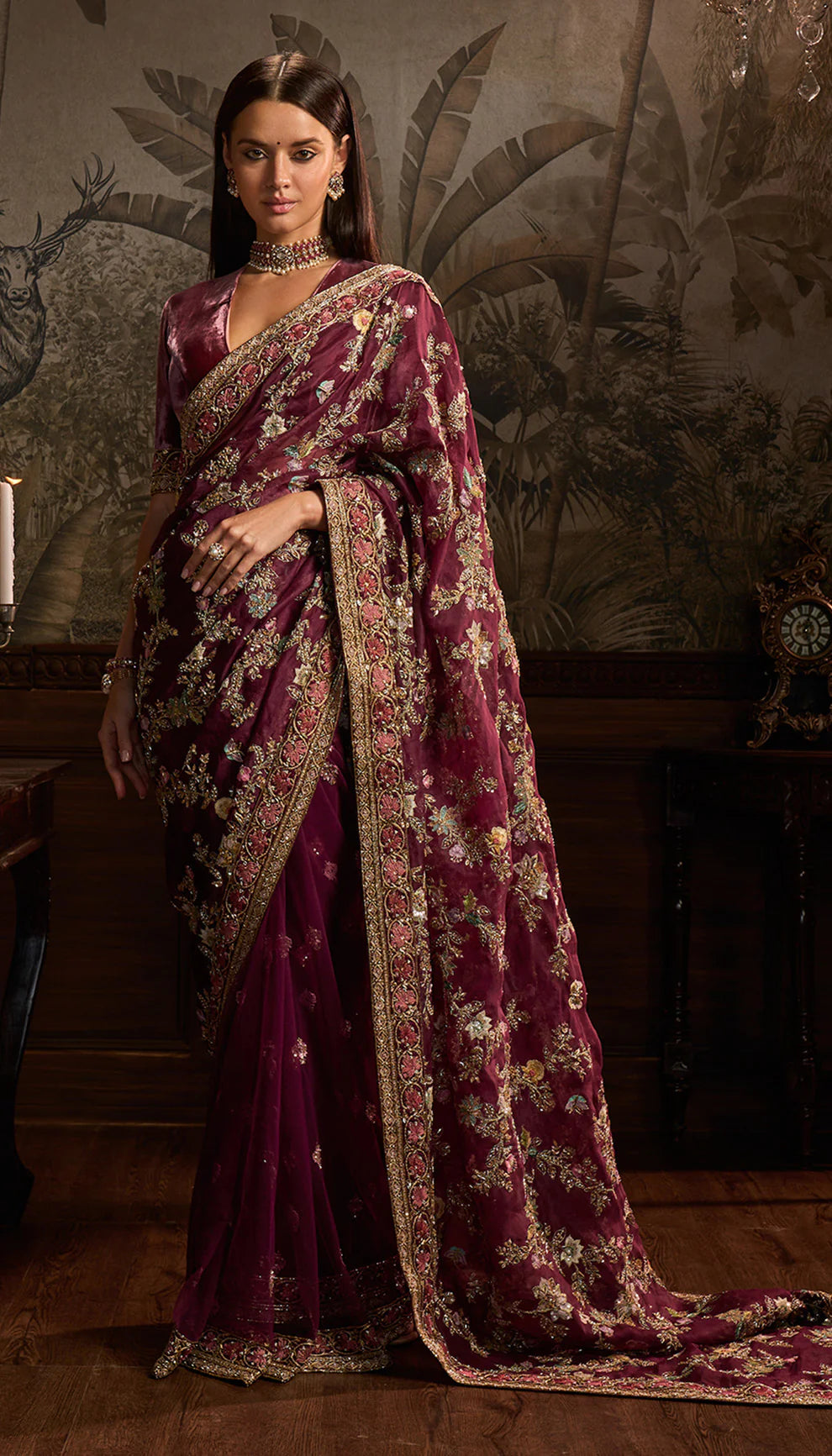 Woman wearing a purple saree with floral patterns by designers Shyamal and Bhumika in a decorative setting