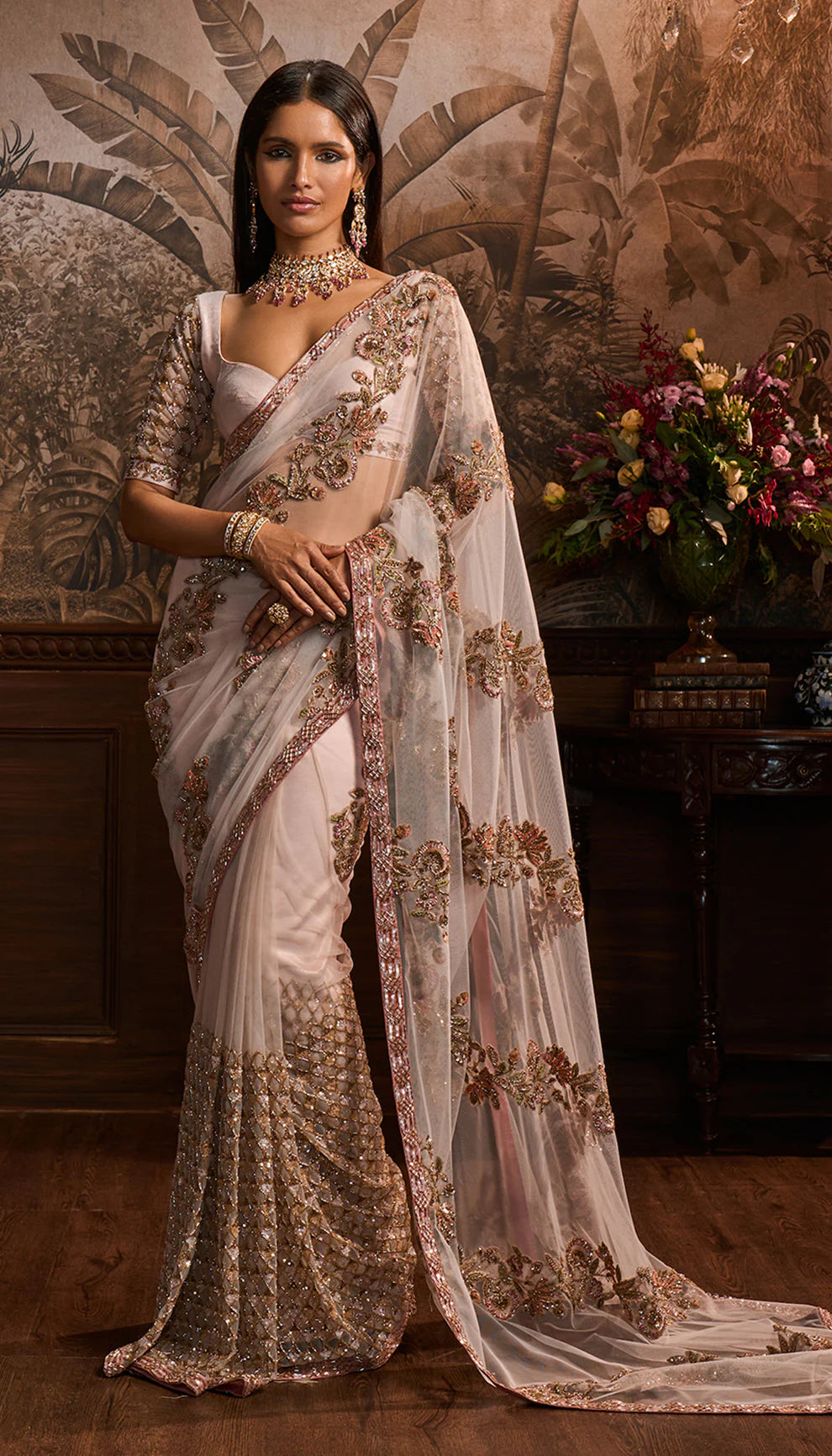 Woman wearing a Shyamal and Bhumika designer traditional saree with intricate designs in a decorative setting.