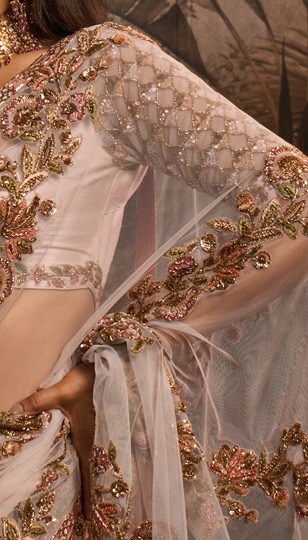 Close-up of a Shyamal and Bhumika saree with intricate gold embroidery on a plain background