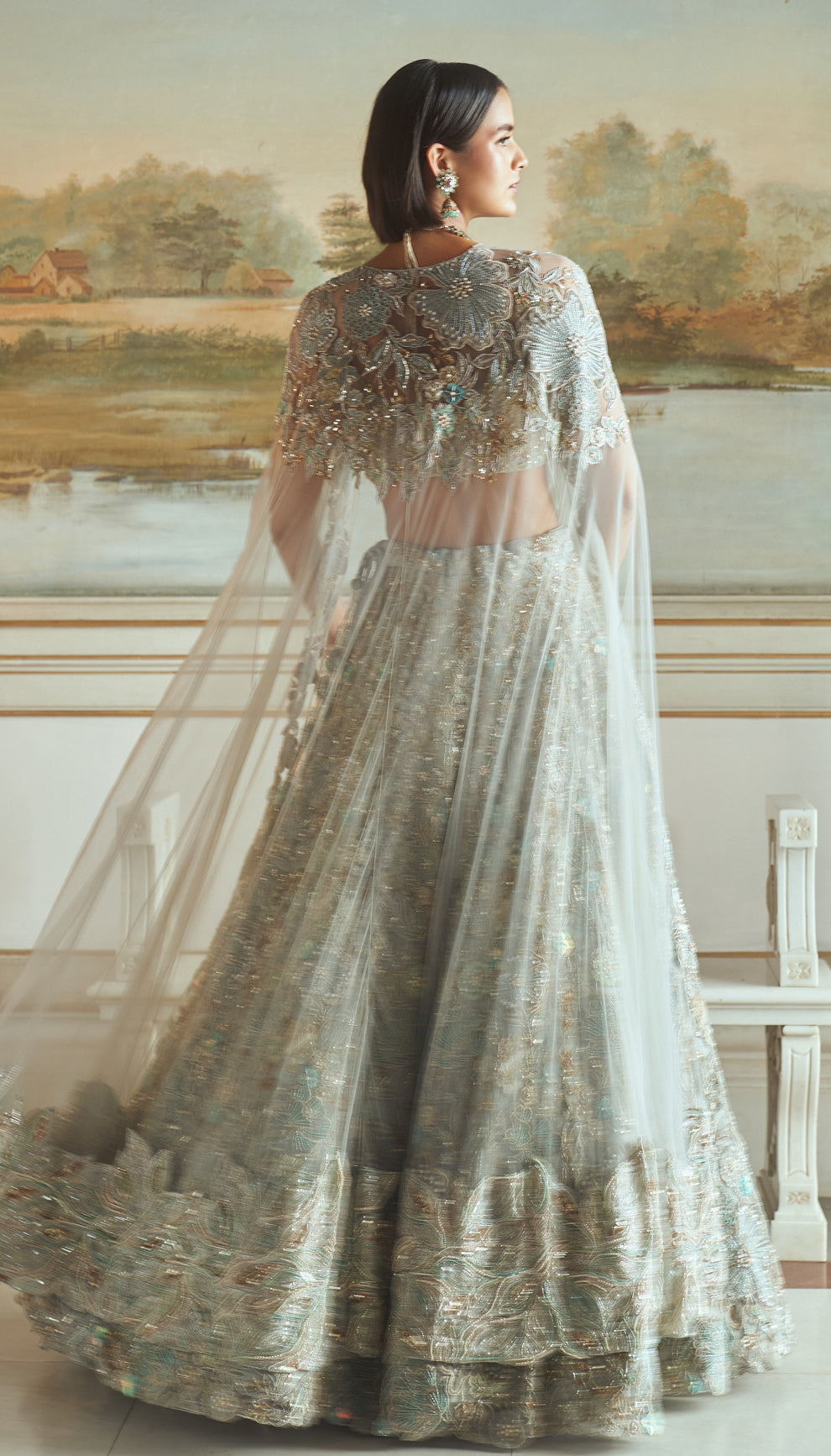 Frost blue, tulle net lehenga, floral embroidery, resham, sequins, glass beads, crystals, sheer tulle net corset blouse, embroidered cape, light blue lehenga, weddings, festive celebrations, evening receptions, destination wedding, sangeet, haldi, mehndi, reception, bridal wear, festive wear, occasion wear, blue lehenga, blue designer lehenga, pastel blue designer lehenga, blue resham work designer lehenga