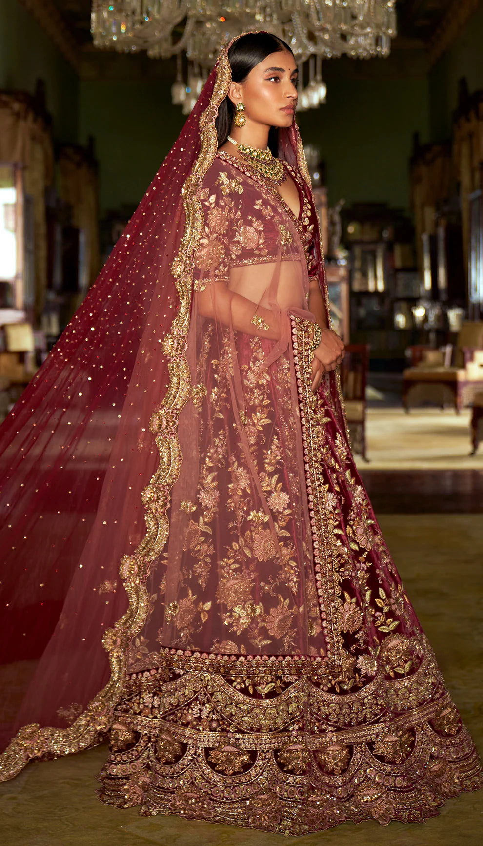 Woman in a traditional maroon and gold embroidered velvet lehenga with a matching dupatta by designers Shyamal and Bhumika.