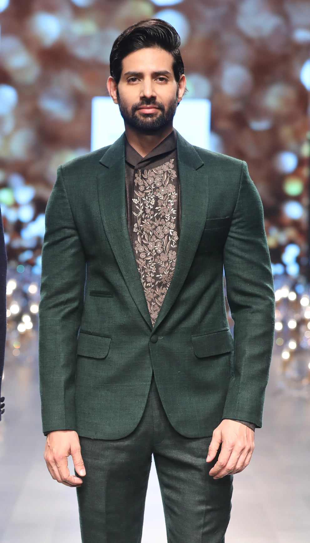 Green matka silk jacket over a black raw silk shirt and trousers