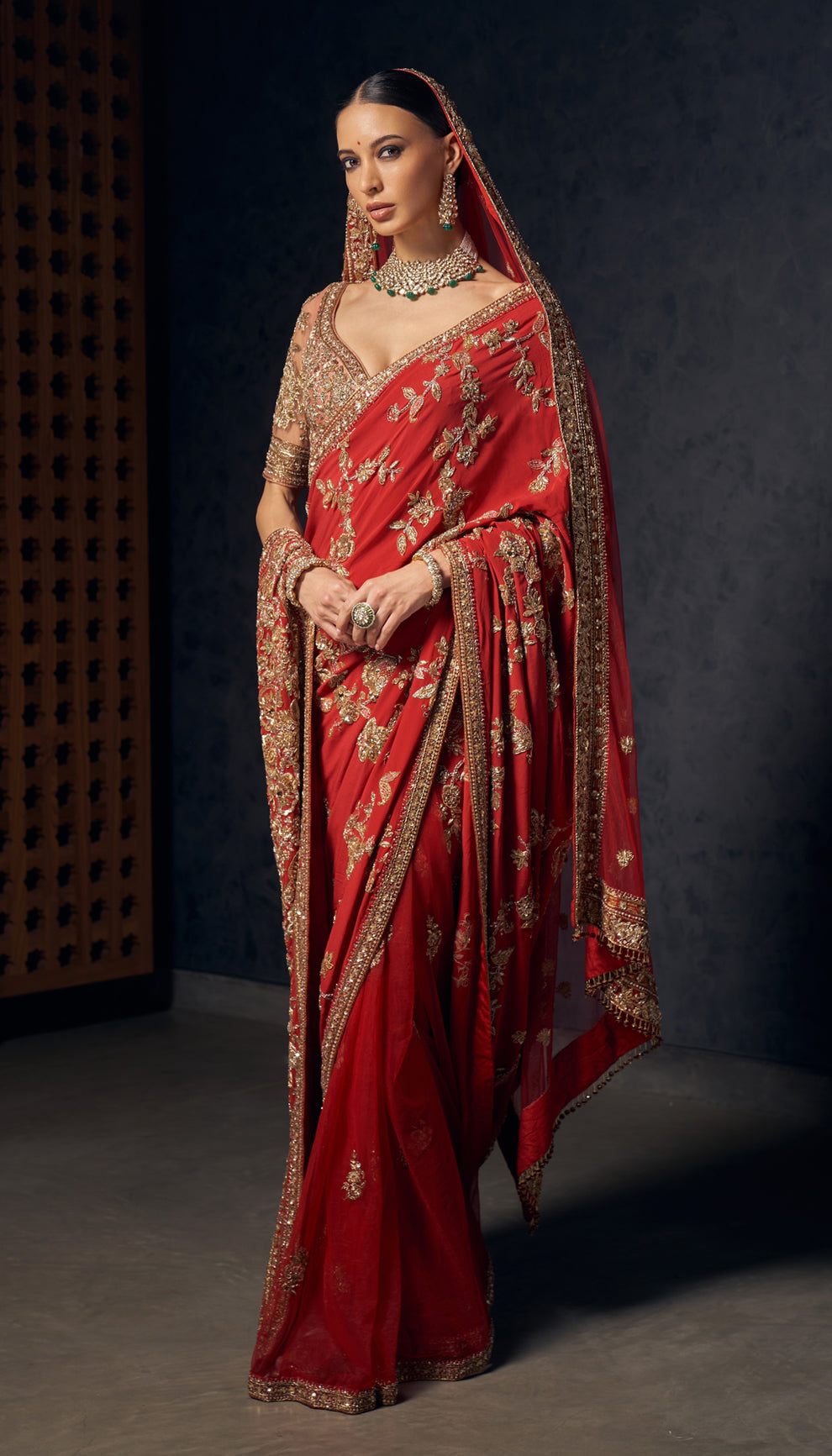 A deep red crepe silk saree with opulent zardozi embroidery,