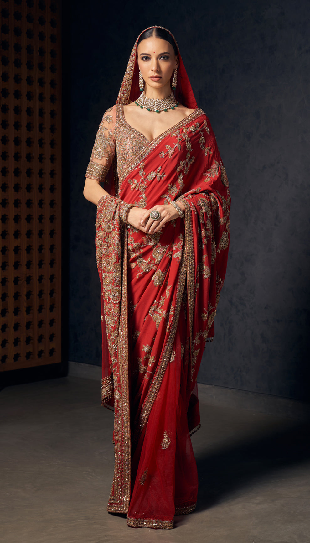 A deep red crepe silk saree with opulent zardozi embroidery,