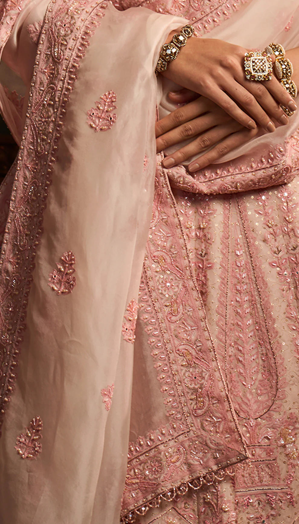 Close-up of a woman wearing a pink embroidered traditional lehenga by designers Shyamal and Bhumika