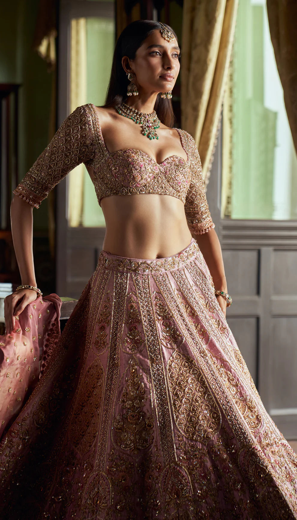 Rose pink, raw silk lehenga, architectural- inspired motifs, zardozi, aari work, sheer tulle net choli, tulle net matching dupatta, pink bridal lehenga, weddings, festive celebrations, evening receptions